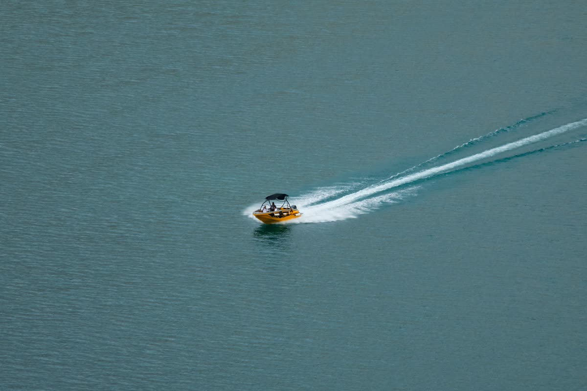 Bateau à moteur vu du dessus, laissant un sillage sur un lac